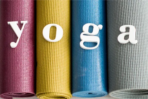 Word "yoga" displayed on rolled yoga mats
