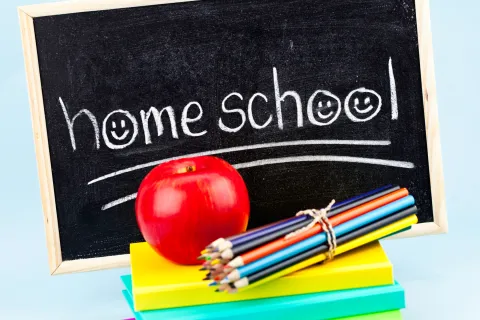 homeschool written on chalkboard plus apple, pencils, and notebooks