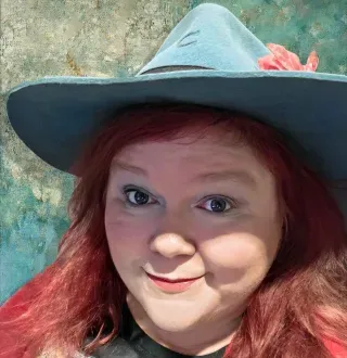 Red haired white woman in a blue hat 